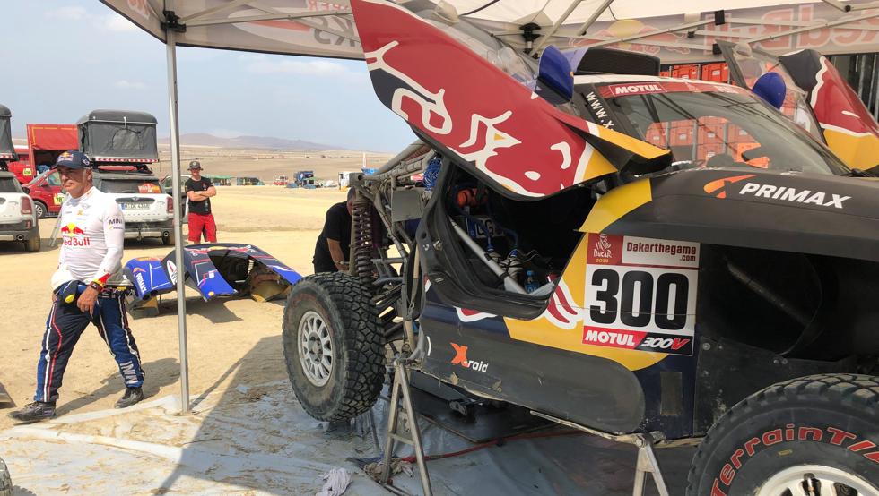 Piloto Carlos Sainz intenta reparar su automóvil contrarreloj para continuar en el Dakar