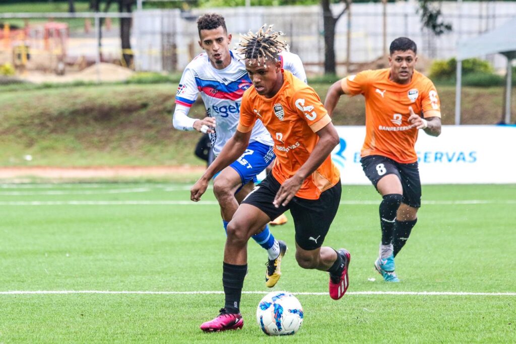 Yunior Peralta (Cibao FC) conduce ante la persecución de Samir De la Rosa (atlético San Cristóbal)