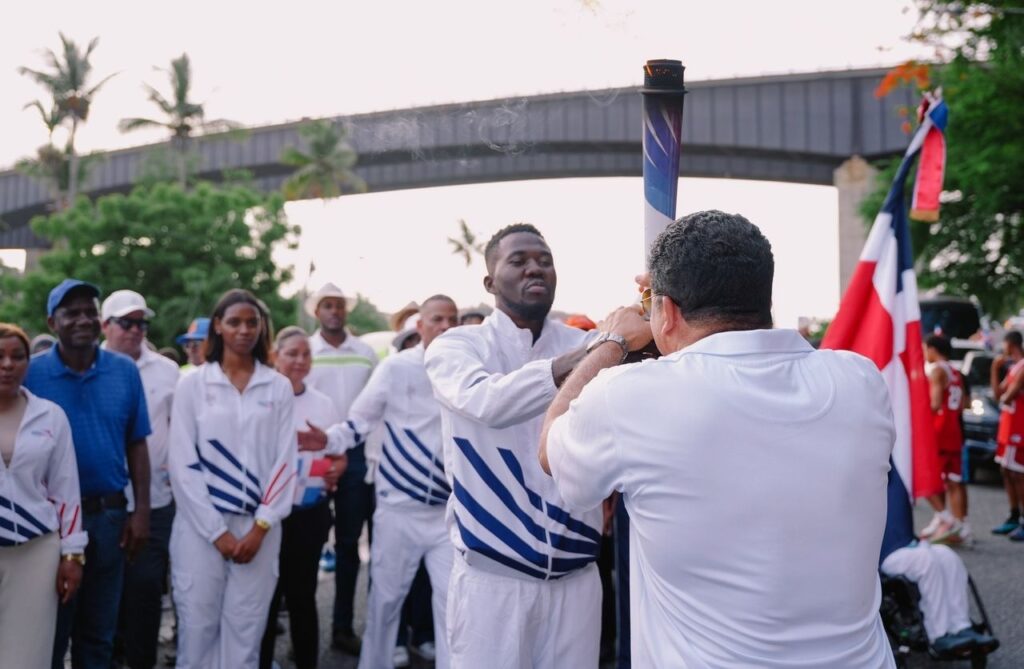 Luisito Pie, múltiple medallista en taekwondo,  recibe la antorcha de manos del alcalde de Santo Domingo Este, Dío Astacio.