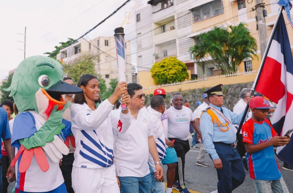 La voleibolista Mía Liberato porta la antorcha de los Juegos Centroamericanos y del Cariber en su paso por Santo Domingo Este.