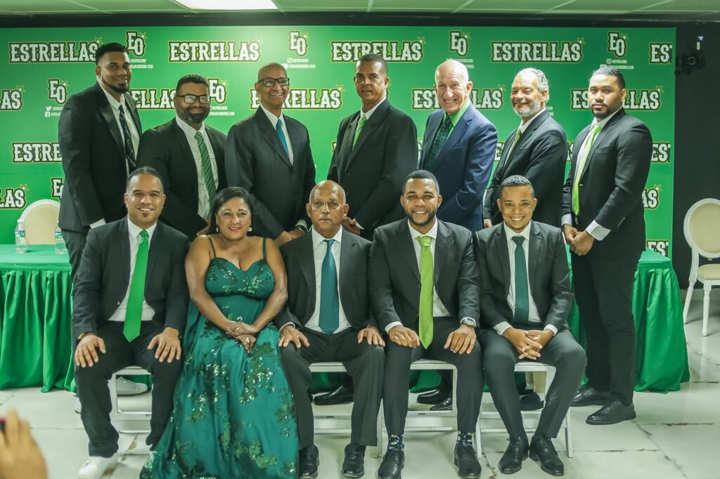 Los integrantes de la Cadena Verde, de las Estrellas Orientales, para las transmisiones de los partidos desde el Estadio Tetelo Vargas, en el venidero torneo de la Liga de Béisbol Profesional de la República Dominicana. Desde la izquierda, aparecen sentados: Manuel Acevedo, Siria Bello, Raffy Ubiera, Luis Enrique Morales, Ángel Luis Mercedes. De pies: Ángel Mota, Filiberto Fernández, Osvaldo Rodríguez Suncar, Luis Morales, Fernando Pérez Ubiera, Ernesto Kranwinkel y Benjamín Martínez.